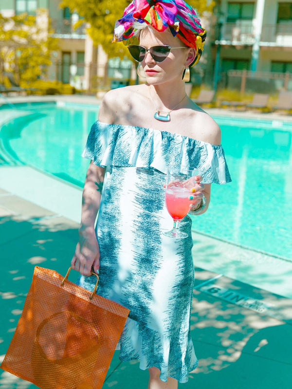 Woman near a pool wearing a summer dress in black and white