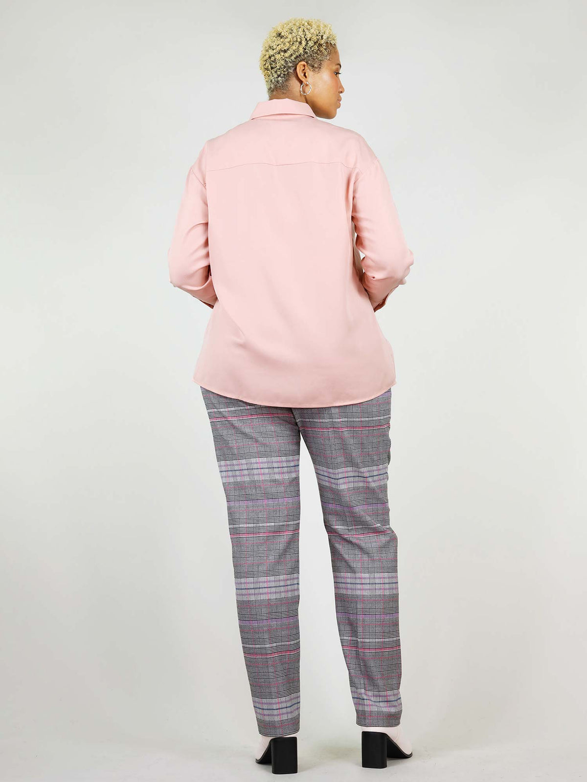 Back shot of the blushing pink, summer shirt. Lose fit around shoulders, hips, and waist for extra added comfort. Nicely roundly shaped around the hips, when worn over trousers.