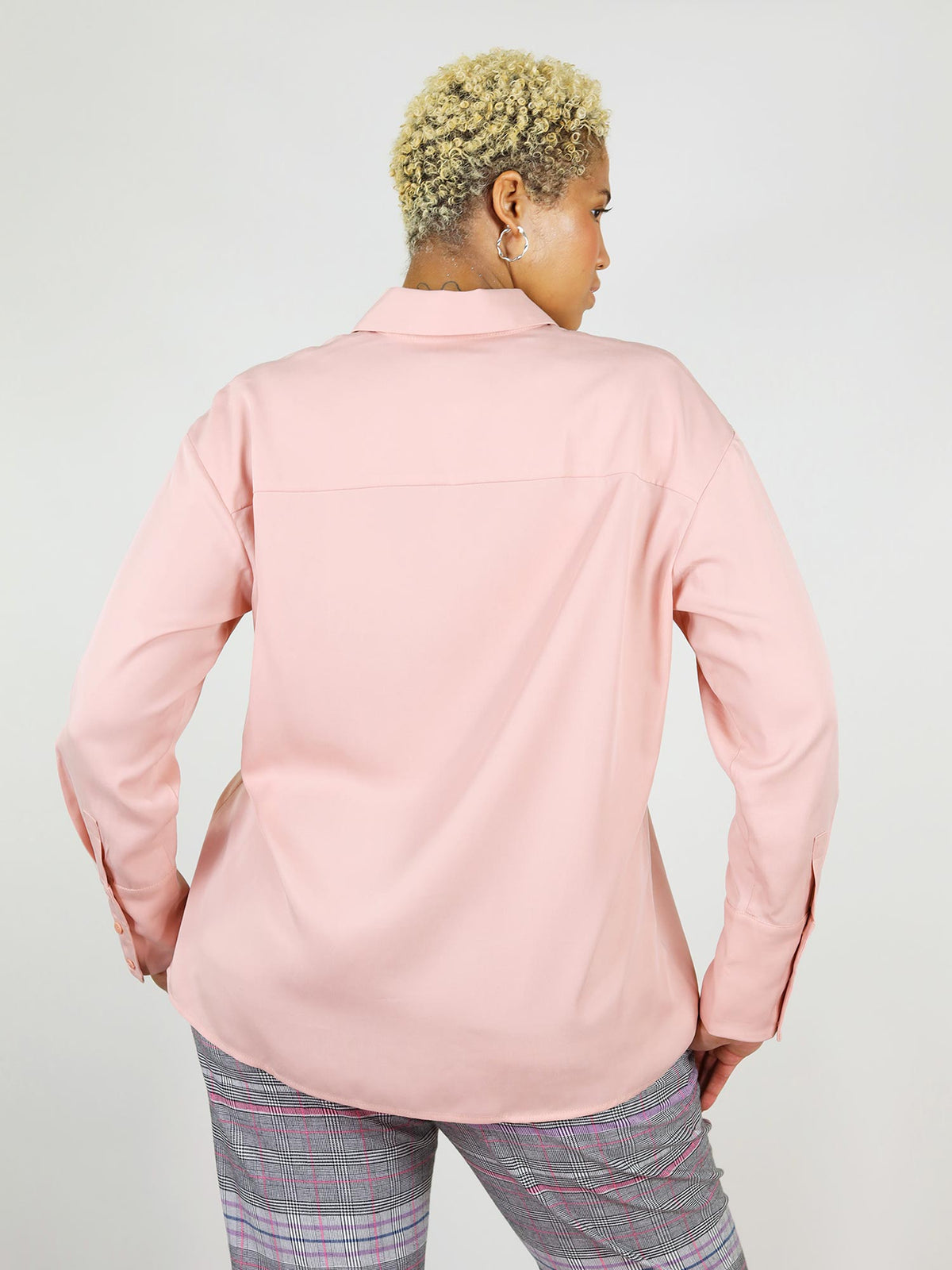 Back close-up shot of the soft, summer shirt in blushing pink. It has a nice lose fit around the waist and hips. Made from 100% Tencel fabric, looks lovely when worn over the trousers.