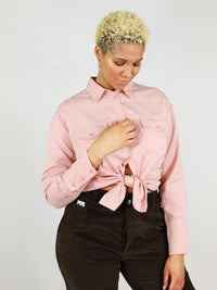 Close-up shot of the blushing pink, summer shirt. It has comfortable fit, two front large pockets, buttoned down and can be tied up in the middle for a sexier look.