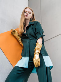 Woman wearing an oversized military green shirt with light blue panel element