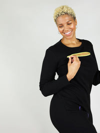 The wicked zipper dress has round neck and yellow zipper under the collar area that unzips. Long sleeves and comes in black.