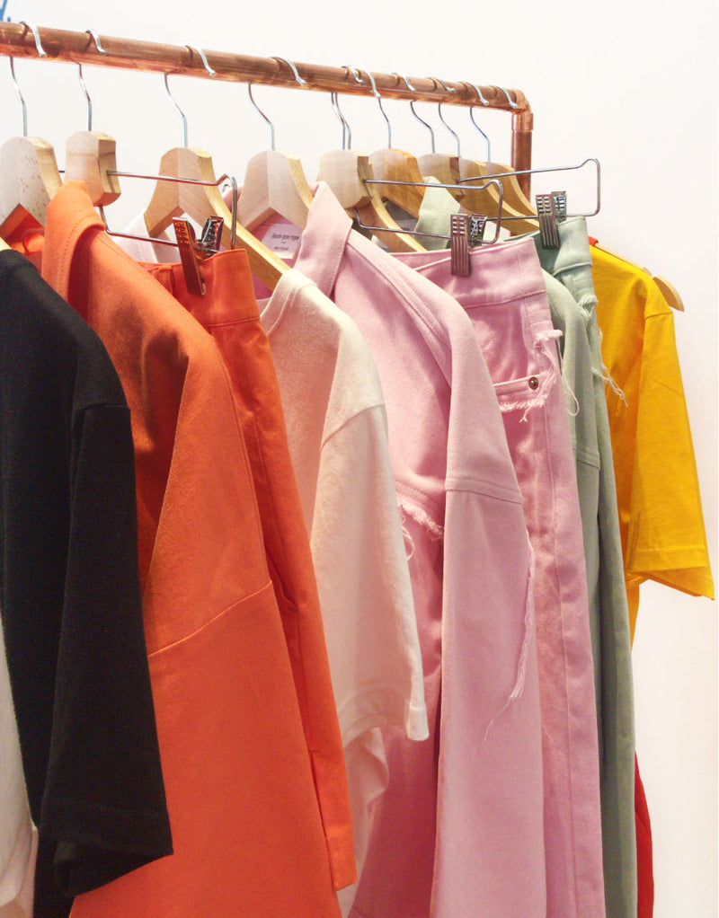 Colourful sustainable upcycled clothing hanging on a rack