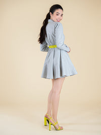Backshot of a woman wearing a grey dress with yellow belt