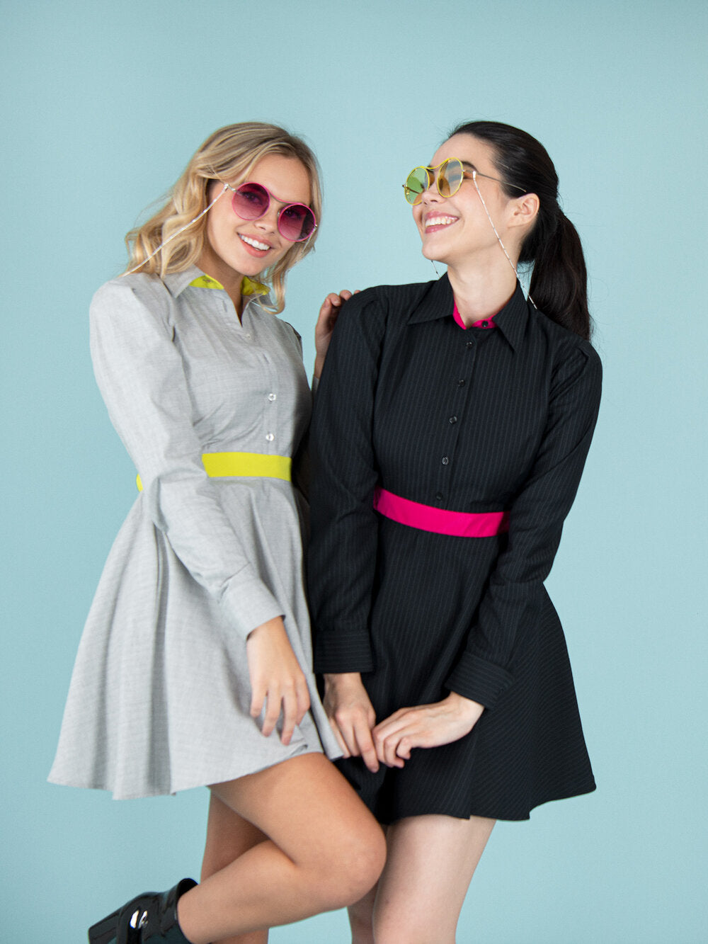 Two women wearing dresses in grey and black with colourful elements