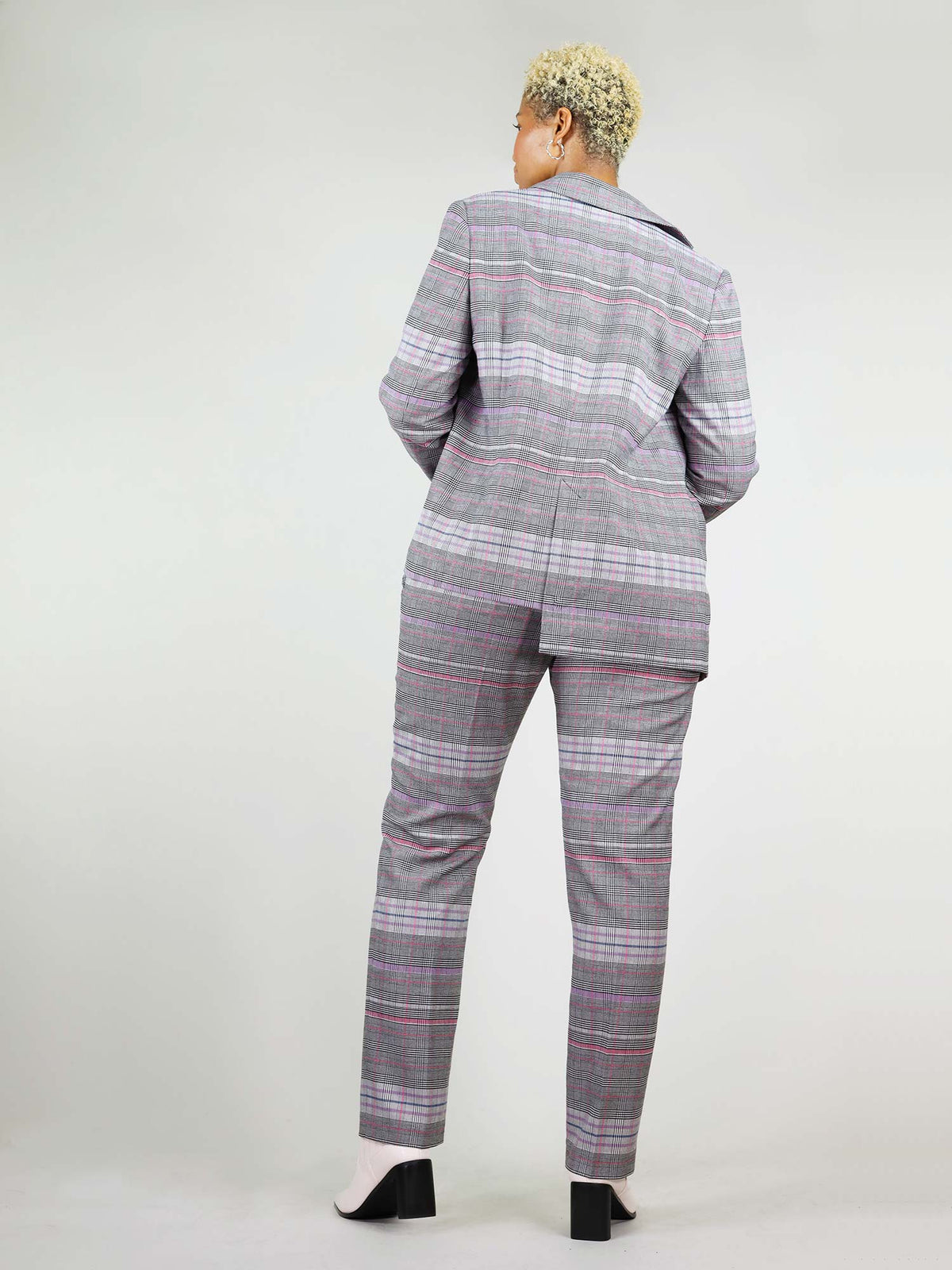 Back of the reivivify blazer in size XL. It has a boxy and asymmetric shape, with one side shorter than the other. Main colours pink and grey.