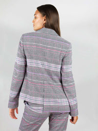The jacket has asymmetric shape, with one back side shorter than the other. The revivify blazer has boxy fit and contrasting pink lining.