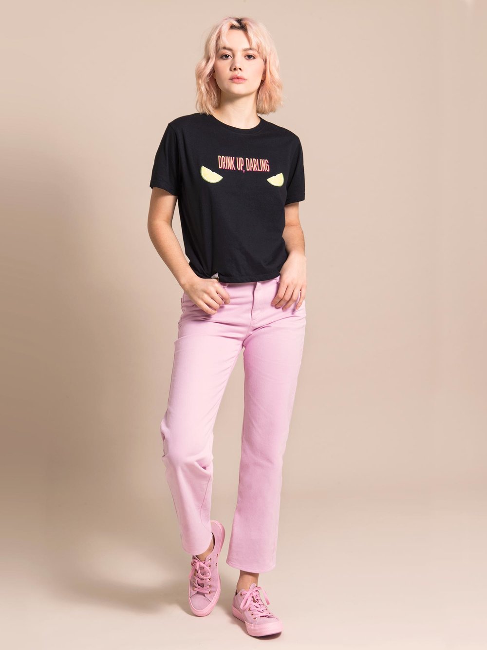 Woman wearing a black tee with print and light pink sustainable jeans