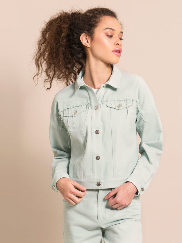 Girl wearing a light blue denim jacket with flared details above the front pockets