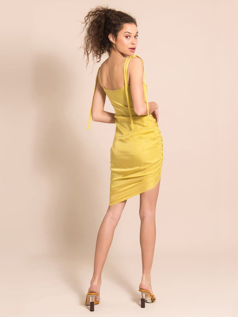 Backshot of a mode wearing a cocktail dress in yellow with adjustable shoulder straps