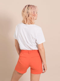 Backshot of a woman wearing a white tee and beige shorts