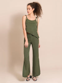 Frontshot of a woman wearing a sustainable military green set - an assymetric top and flared silky trousers