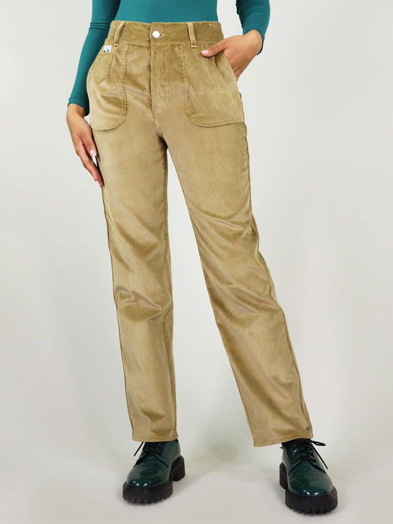Closer view at the high waist corduroy trousers in autumn beige. Loose fit, easy to tuck in a shirt. Large side pockets with signature logo on the left side and belt loops.