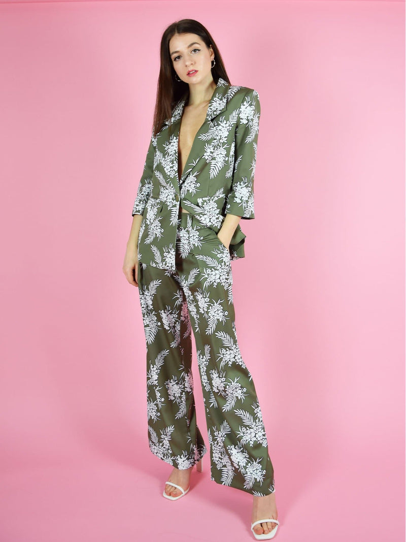 Frontshot of the girlboss trouser suit in green with white floral print. The pant suit consists of high waisted wide leg trousers and longline oversized blazer.