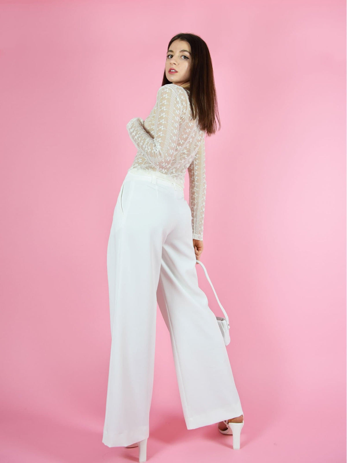 Backshot of blonde gone rogue's girlboss sustainable wide leg trousers in white. The trousers feature wide-leg design for comfort and freedom of movement.