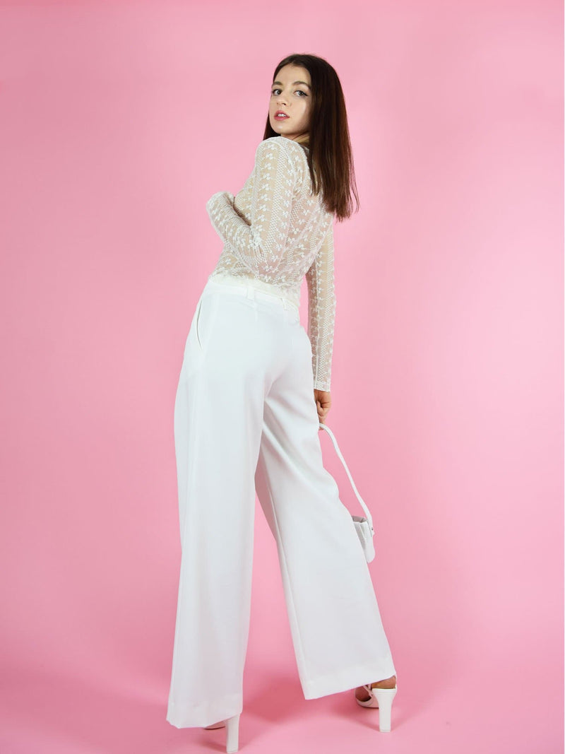 Backshot of blonde gone rogue's girlboss sustainable wide leg trousers in white. The trousers feature wide-leg design for comfort and freedom of movement.