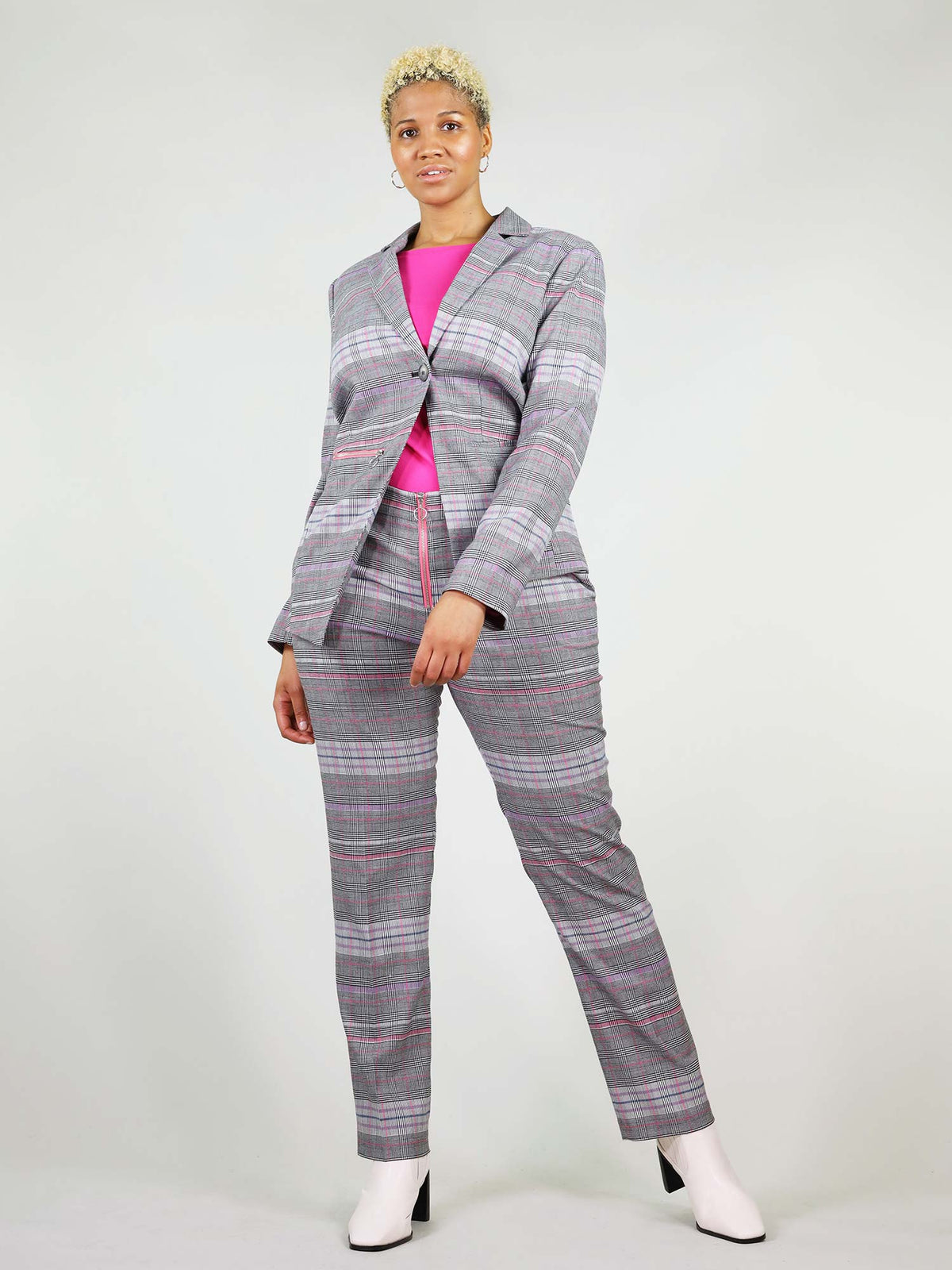 The revivify blazer in pink and grey is button fastening and boxy fit. It has asymmetric design and colourful details. 