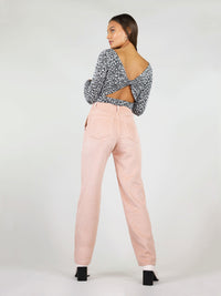 Back shot of the corduroy trousers in pastel pink. High waist and straight leg fit, with two large back pockets. Loose fit and belt loops.