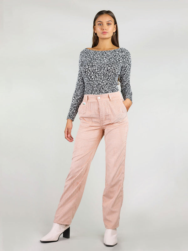 Full body shot of the high waist, pastel pink, corduroy trousers. Straight leg fit and button fastening. Two large side pockets with signature logo on the left side.