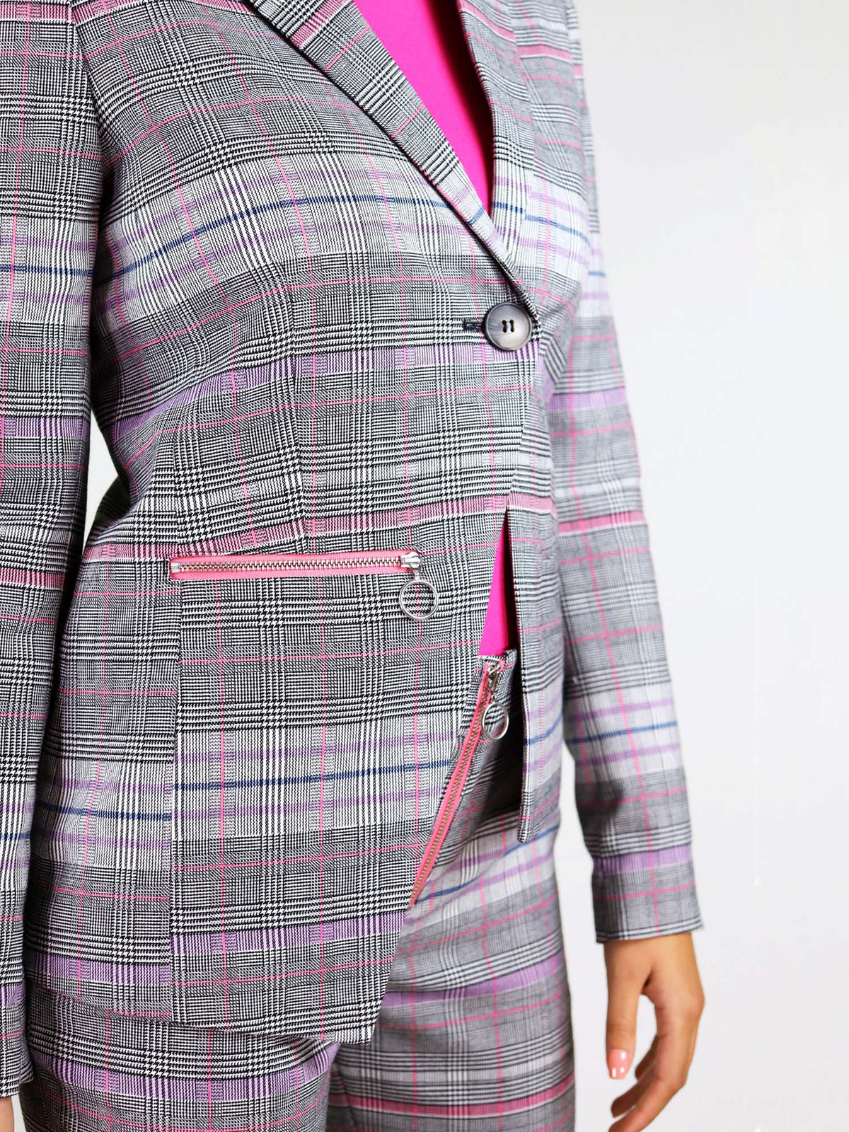 The revivify pink and grey blazer has asymmetric shape design and bxy fit. It also has a pocket with pink metal zip with ring puller on one of the sides. 