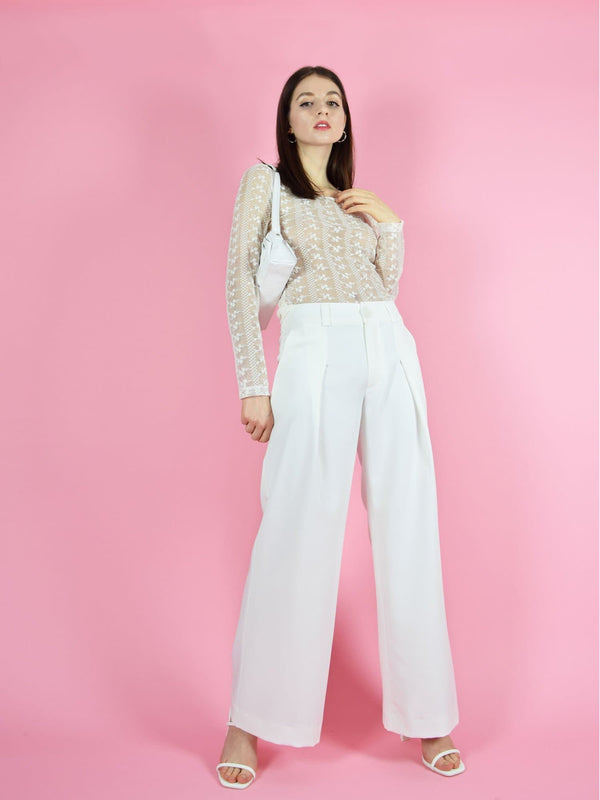 blonde gone rogue's girlboss sustainable trousers in white perfect for wedding guests and other formal occasions. The pants are paired with the daisy long-sleeve lace top in white.