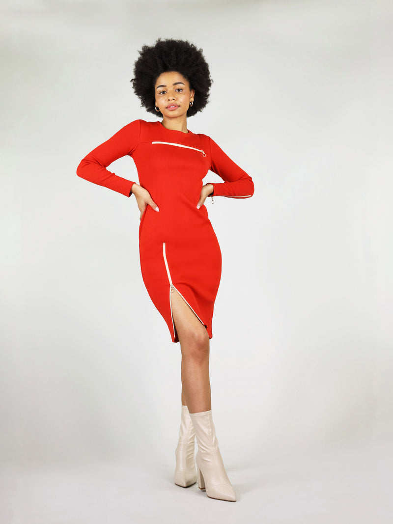 The wicked zipper dress in red has long sleeves with a white zip on the left arm, under knee length and white zip on the right leg that unzips, revealing the leg. Also has tight body con fit.