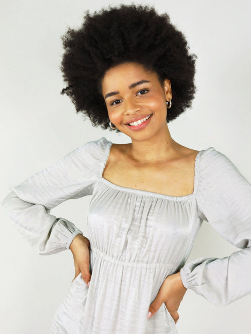 Close up-front view of the silver midi empire dress. Square neck and elastic around shoulders, can be worn on and off. Long sleeve and elastic at the cuffs. Elastic under bust and around cleavage.