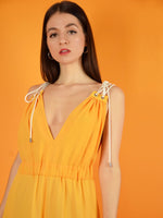 close-up of the eternal summer jumpsuit in orange - it has a beautiful v-neck cleavage. design by blonde gone rogue.