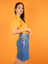 side shot of blonde gone rogue's lace up short denim skirt and wildflower sustainable surplice top in orange.